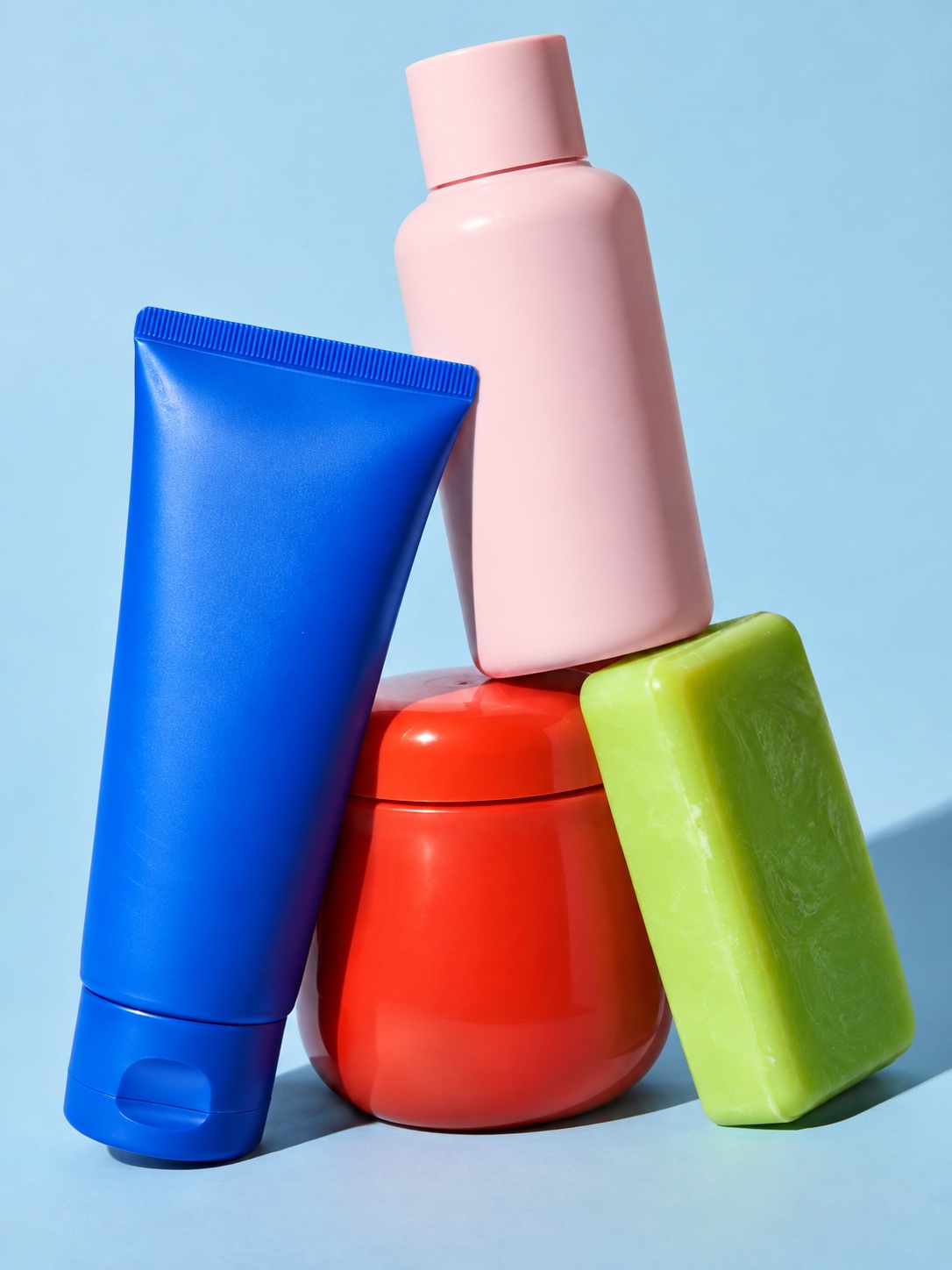 Colorful blue, pink, red, and lime beauty and wellness packaging in a playful studio still life